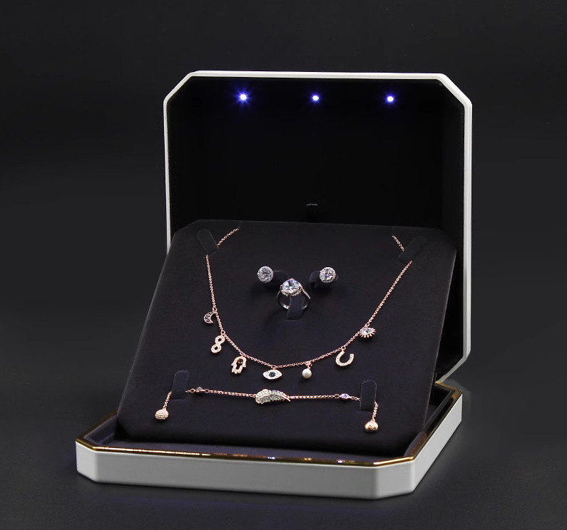 Luxury jewelry foam pad display with LED lights, showcasing high-end rings and necklaces in an elegant setting.