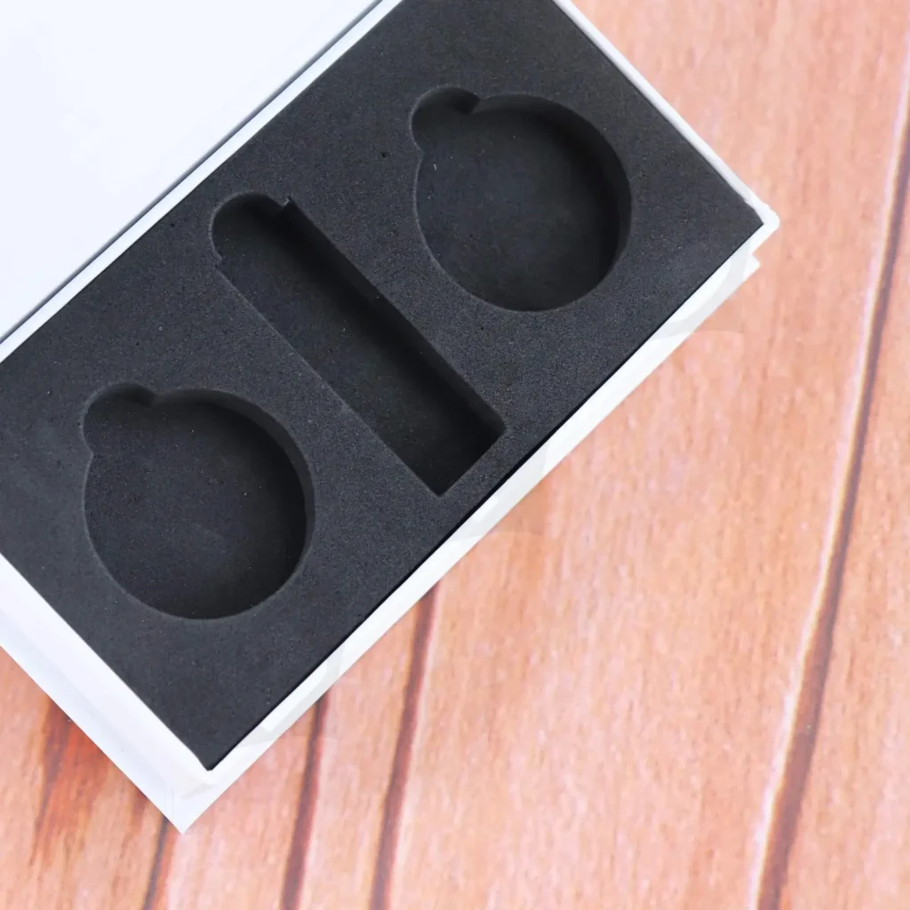 Black EVA insert with precision-cut cavities used to securely hold candle jars and accessories inside rigid gift boxes.