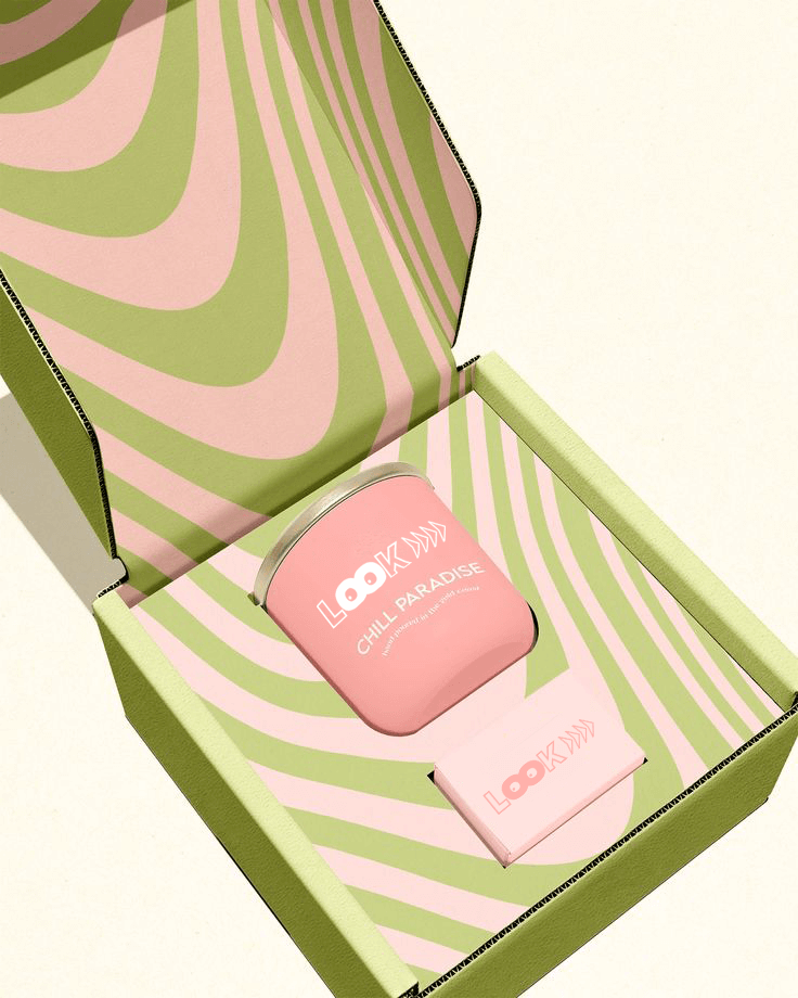 Custom pink and green candle packaging set in a printed corrugated mailer box, featuring a branded candle and matchbox with bold psychedelic design.