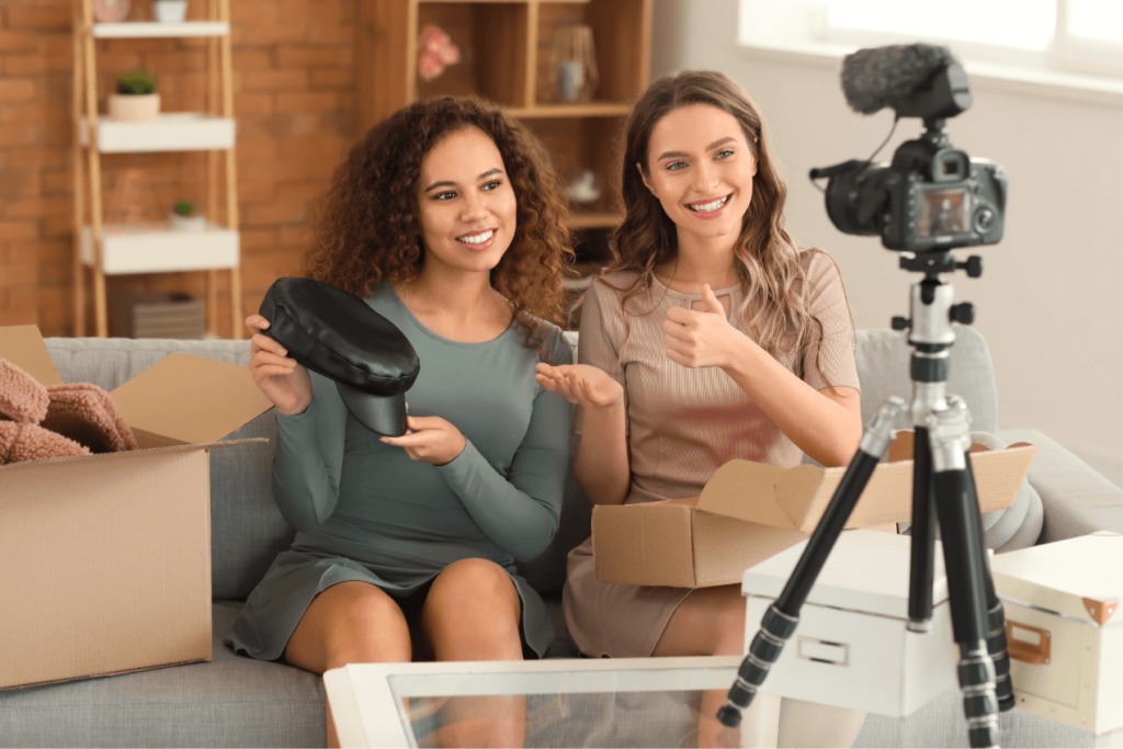 Two female influencers filming an unboxing video for social media as part of an influencer marketing campaign.