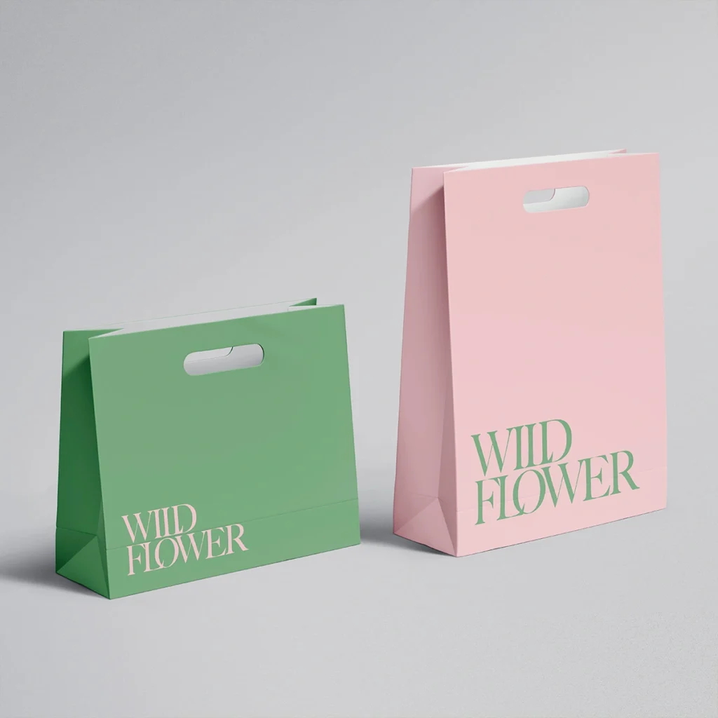Minimalist green and pink paper bags with die cut handles, custom retail packaging for fashion and boutiques