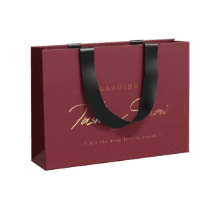 Custom clothing packaging bag with gold foil logo and black ribbon handles – ideal for fashion brands seeking a luxurious retail look.